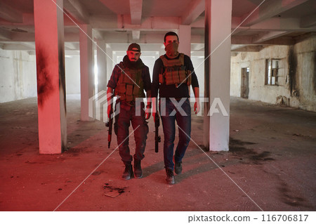 An abandoned building serves as the stronghold for a team of terrorists, fiercely guarding their occupied territory with guns and military equipment 116706817