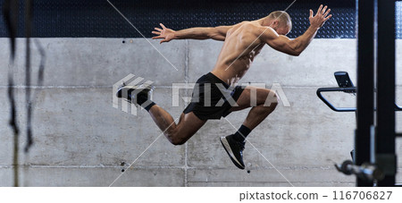 A muscular man captured in air as he jumps in a modern gym, showcasing his athleticism, power, and determination through a highintensity fitness routine A muscular man captured in air as he jumps in a modern gym, showcasing his athleticism, power, and determination through a highintensity fitness routine 116706827