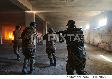 A group of professional soldiers bravely executes a dangerous rescue mission, surrounded by fire in a perilous building. 116706868