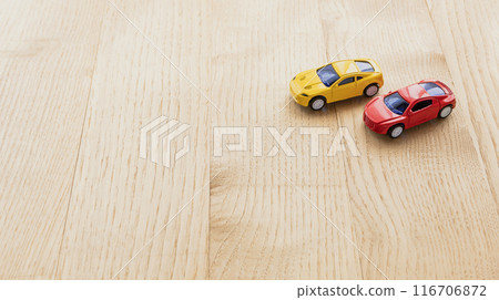 Red and yellow miniature cars on a wooden table 116706872