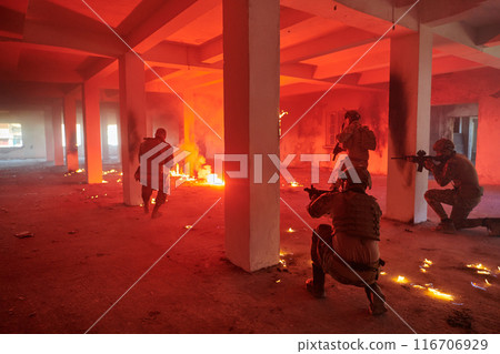 A group of professional soldiers bravely executes a dangerous rescue mission, surrounded by fire in a perilous building. 116706929