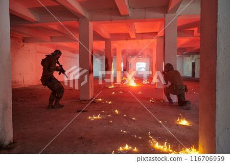 A group of professional soldiers bravely executes a dangerous rescue mission, surrounded by fire in a perilous building. 116706959