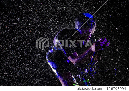 A triathlete braving the rain as he cycles through the night, preparing himself for the upcoming marathon A triathlete braving the rain as he cycles through the night, preparing himself for the upcoming marathon 116707094