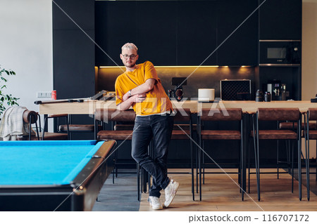 A man takes a brief rest from work in a modern startup coworking center, using the moment to recharge and relax with technology by his side. A man takes a brief rest from work in a modern startup coworking center, using the moment to recharge and relax with technology by his side. 116707172