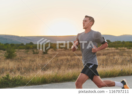 A young handsome man running in the early morning hours, driven by his commitment to health and fitness A young handsome man running in the early morning hours, driven by his commitment to health and fitness 116707211