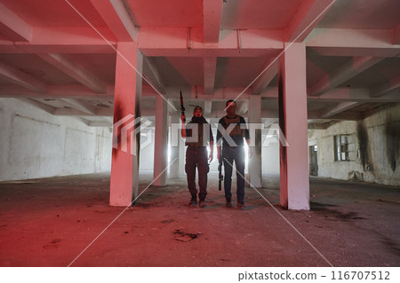 An abandoned building serves as the stronghold for a team of terrorists, fiercely guarding their occupied territory with guns and military equipment 116707512