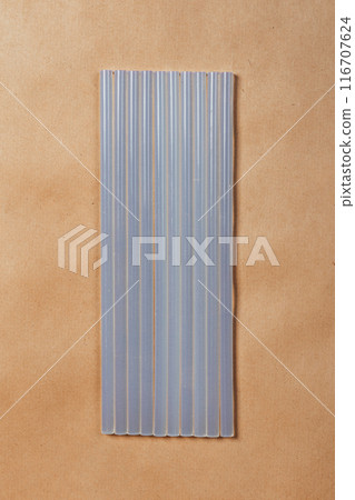 hot glue sticks on brown paper background. rods for pistol gluing objects 116707624