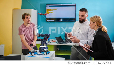 A group of students working together in a laboratory, dedicated to exploring the aerodynamic capabilities of a drone A group of students working together in a laboratory, dedicated to exploring the aerodynamic capabilities of a drone 116707654