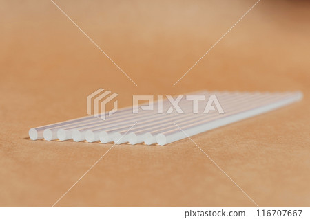 hot glue sticks on brown paper background. rods for pistol gluing objects hot glue sticks on brown paper background. rods for pistol gluing objects 116707667