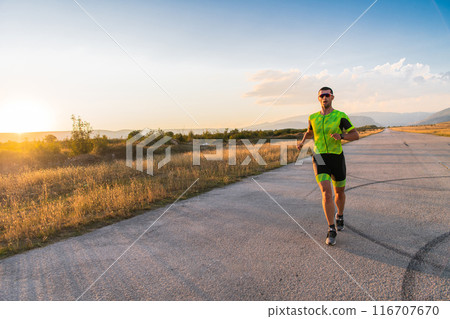 Triathlete in professional gear running early in the morning, preparing for a marathon, dedication to sport and readiness to take on the challenges of a marathon. Triathlete in professional gear running early in the morning, preparing for a marathon, dedication to sport and readiness to take on the challenges of a marathon. 116707670