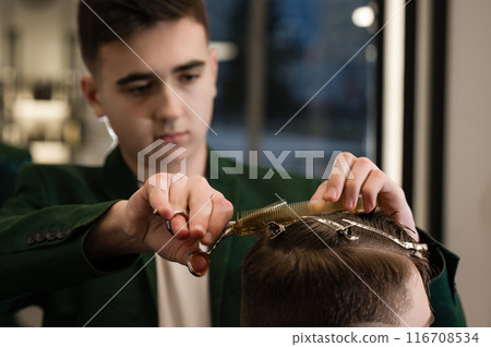 Haircut alignment of the contour of the head with scissors. Short haircut in the barbershop. Haircut alignment of the contour of the head with scissors. Short haircut in the barbershop. 116708534