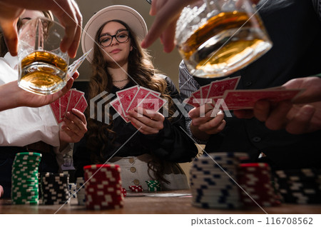 A team rejoices at a poker win against the background of glasses of whiskey. A team rejoices at a poker win against the background of glasses of whiskey. 116708562