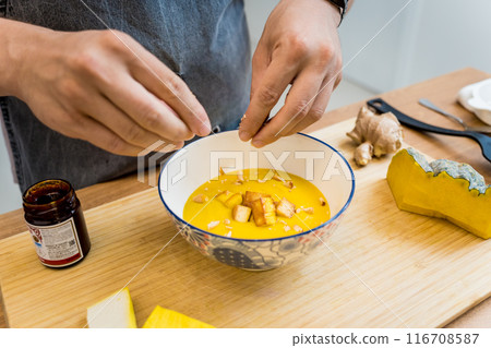 Chef at the kitchen preparing pumpkin porridge with tofu and vegetables Chef at the kitchen preparing pumpkin porridge with tofu and vegetables 116708587
