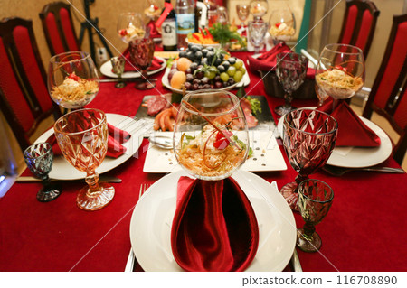 Bright festive table in a restaurant with dishes and cutlery beautifully arranged Bright festive table in a restaurant with dishes and cutlery beautifully arranged 116708890