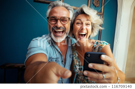 An elderly couple captures joyful moments at home using a smartphone, embracing modern technology for shared memories and social media moments.Generated image An elderly couple captures joyful moments at home using a smartphone, embracing modern technology for shared memories and social media moments.Generated image 116709140
