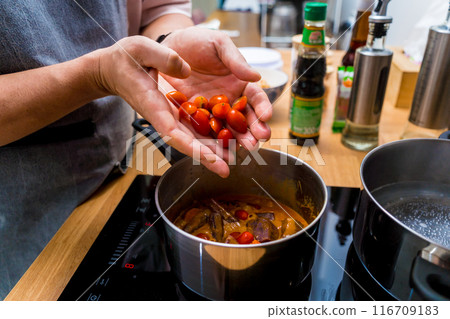 Chef at the kitchen preparing massaman curry with sweet potato and many spices Chef at the kitchen preparing massaman curry with sweet potato and many spices 116709183