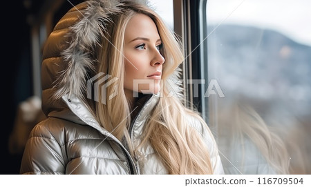 Mesmerized by the snowy panorama, a woman's smile radiates a sense of blissful solitude, embracing the magic of solo travel amidst the winter scenery 116709504