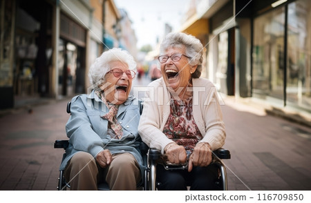 In a nursing home, two elderly women in wheelchairs find joy and companionship, embracing the comfort of their shared moments.Generated image 116709850