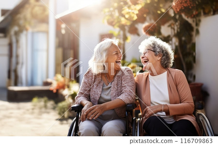 In a nursing home, two elderly women in wheelchairs find joy and companionship, embracing the comfort of their shared moments.Generated image 116709863