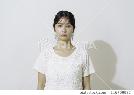 白色背景下穿著白色衣服的年輕女子的肖像 116709982