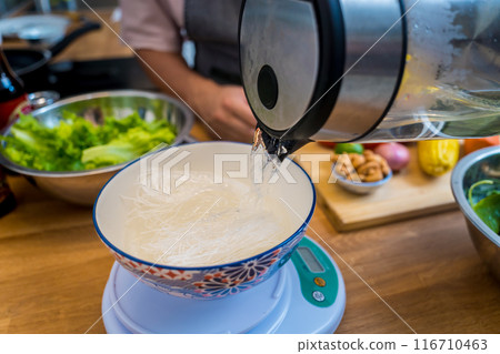 Chef at the kitchen preparing spicy glass noodle salad 116710463