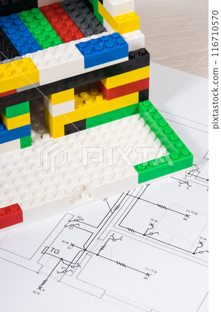 Housing plan with electric installation, house under construction made of toy blocks 116710570