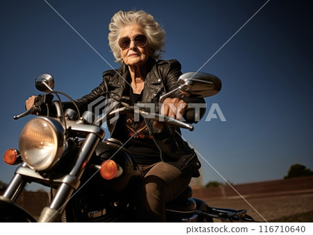 An adventurous elderly woman embraces a modern lifestyle as she travels the world, riding a motorcycle through diverse landscapes, symbolizing her free-spirited and courageous approach to exploration 116710640