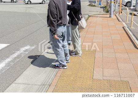 Parents and children waiting for a traffic light 116711007