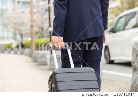 帶著行李箱走在人行道上的商人 帶著行李箱走在人行道上的商人 116711014