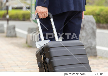 Businessman walking down the sidewalk with a suitcase Businessman walking down the sidewalk with a suitcase 116711045
