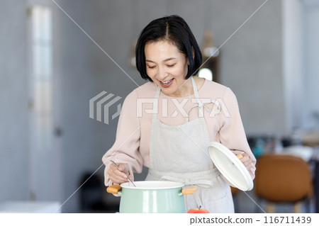 Middle women standing in the kitchen Middle women standing in the kitchen 116711439