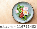 Asparagus and poached eggs with jamon and radishes 116711462