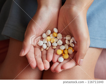 Many different kinds of medicine tablets and a child's hand Many different kinds of medicine tablets and a child's hand 116711840
