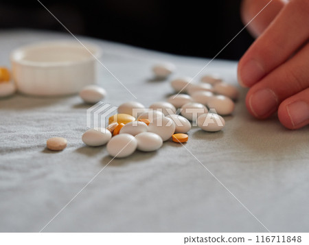 Many different kinds of medicine tablets and a child's hand Many different kinds of medicine tablets and a child's hand 116711848