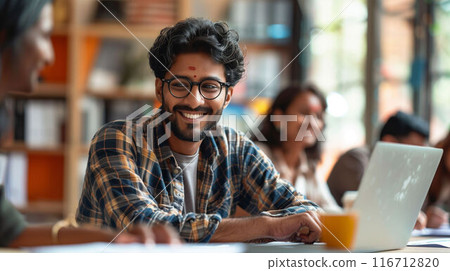 Man sitting at table with laptop 116712820