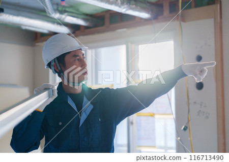 Male craftsman carrying materials at a construction site Male craftsman carrying materials at a construction site 116713490