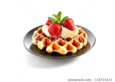 Freshly baked waffles decorated with strawberries and cream, cutout on white background Freshly baked waffles decorated with strawberries and cream, cutout on white background 116714213