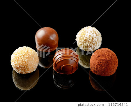Assortment of rich chocolate bonbons, cut out on black background Assortment of rich chocolate bonbons, cut out on black background 116714241