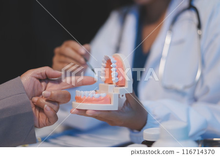 Dentist and patient discussion about planned dental treatment in dental clinic office, doctors talk and work. health care talk medical conference concept 116714370