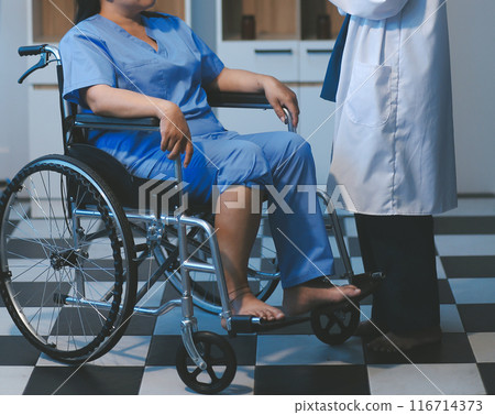 Asian young professional successful friendly female nurse in blue hospital uniform helping supporting physical therapy senior old pensioner unhealthy injury woman patient walking via four legs walker. Asian young professional successful friendly female nurse in blue hospital uniform helping supporting physical therapy senior old pensioner unhealthy injury woman patient walking via four legs walker. 116714373