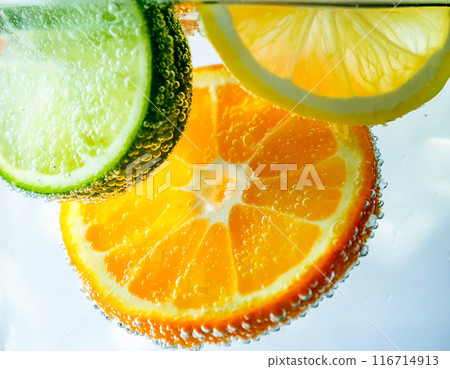 Close-up of orange, lime and lemon submerged in carbonated water 116714913