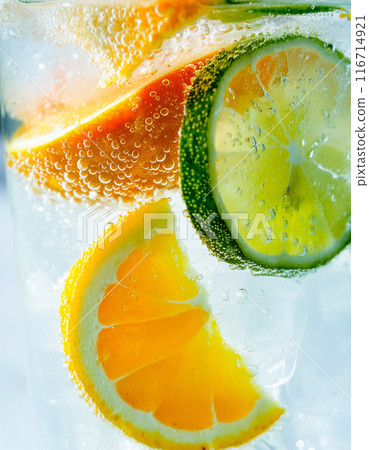 Close-up of orange, lime and lemon submerged in carbonated water 116714921