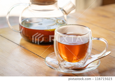 Warm Glass Teapot with Freshly Brewed Tea on Wooden Table - Cozy Beverage Moment 116715023