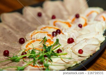 Meat cuts on a white black plate on a wooden table Meat cuts on a white black plate on a wooden table 116716531
