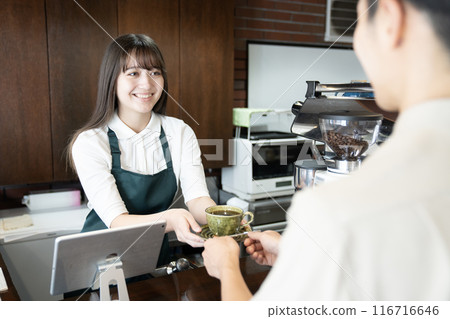 一位女咖啡館員工給顧客咖啡 一位女咖啡館員工給顧客咖啡 116716646