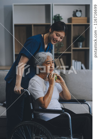 Asian physiotherapist helping elderly woman patient stretching arm during exercise correct with dumbbell in hand during training hand with patient Back problems in garden. Nursing home hospital Asian physiotherapist helping elderly woman patient stretching arm during exercise correct with dumbbell in hand during training hand with patient Back problems in garden. Nursing home hospital 116716699