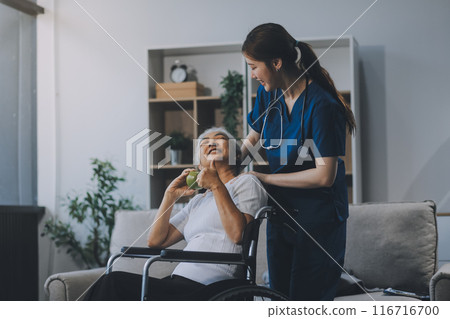 Asian physiotherapist helping elderly woman patient stretching arm during exercise correct with dumbbell in hand during training hand with patient Back problems in garden. Nursing home hospital Asian physiotherapist helping elderly woman patient stretching arm during exercise correct with dumbbell in hand during training hand with patient Back problems in garden. Nursing home hospital 116716700