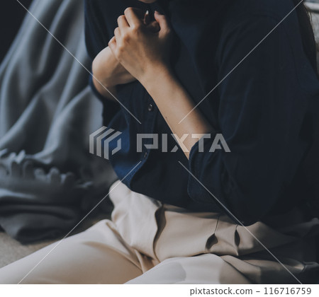 A woman with a cold with pills is treated at home chooses which drugs to take and self-medicates, checks the expiration date while sitting on the couch at home 116716759