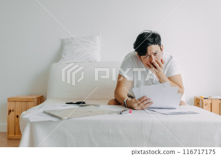 Man feeling serious with the paper works and loaning bills account. Man feeling serious with the paper works and loaning bills account. 116717175