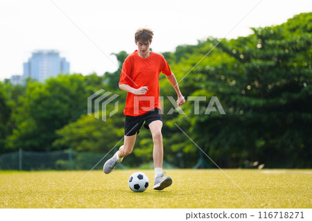 Young man playing football. 116718271